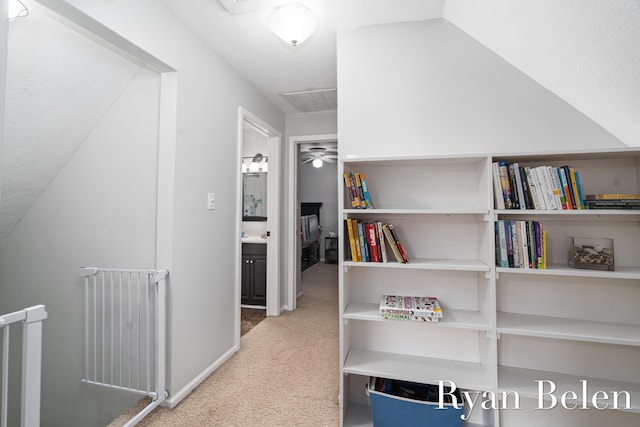 hall featuring lofted ceiling and carpet flooring