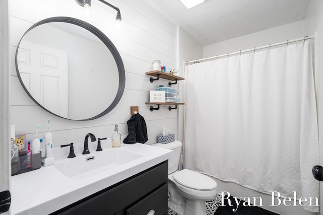 bathroom with walk in shower, vanity, and toilet