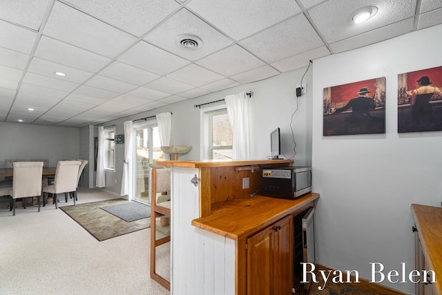 interior space featuring a paneled ceiling and carpet