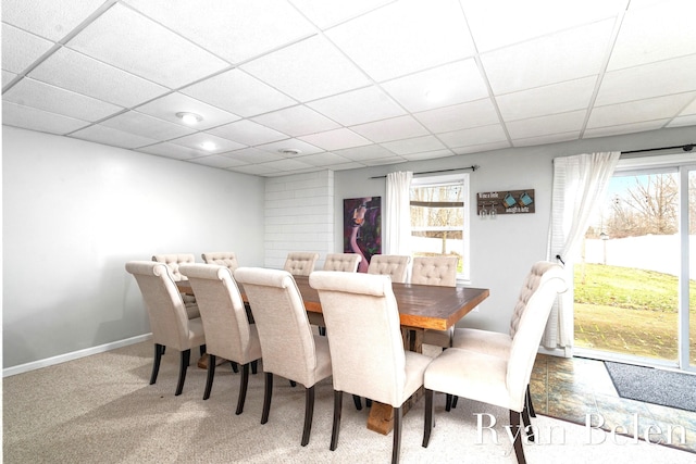 carpeted dining space featuring a drop ceiling