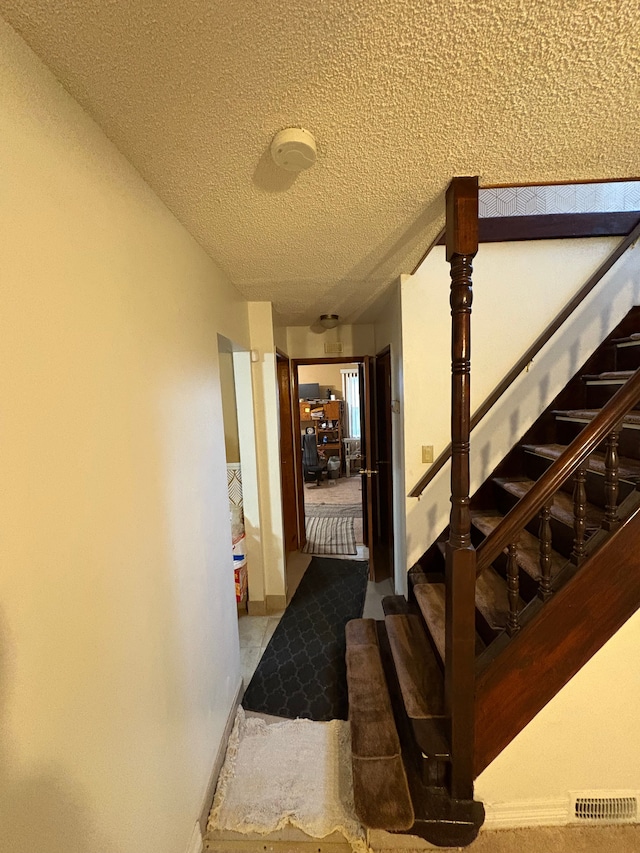 stairway with a textured ceiling