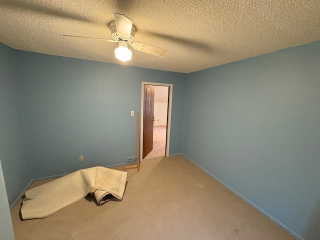 bedroom featuring ceiling fan, carpet flooring, and a textured ceiling