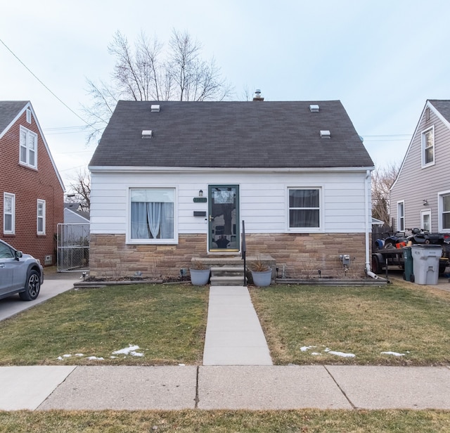 bungalow-style home with a front lawn