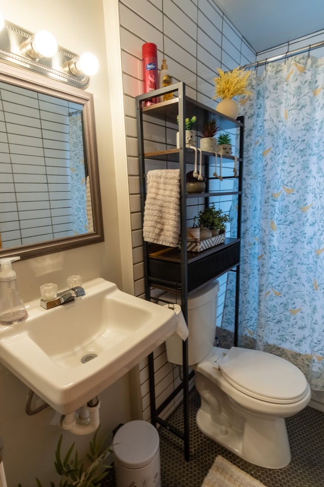 bathroom featuring a shower with curtain, tile patterned floors, toilet, and sink