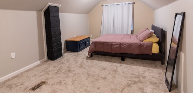 bedroom featuring light colored carpet and lofted ceiling