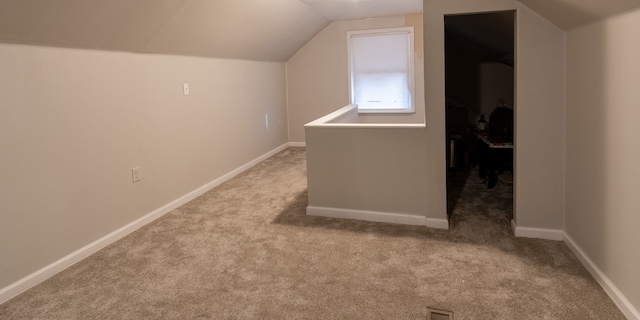 bonus room featuring lofted ceiling and light carpet