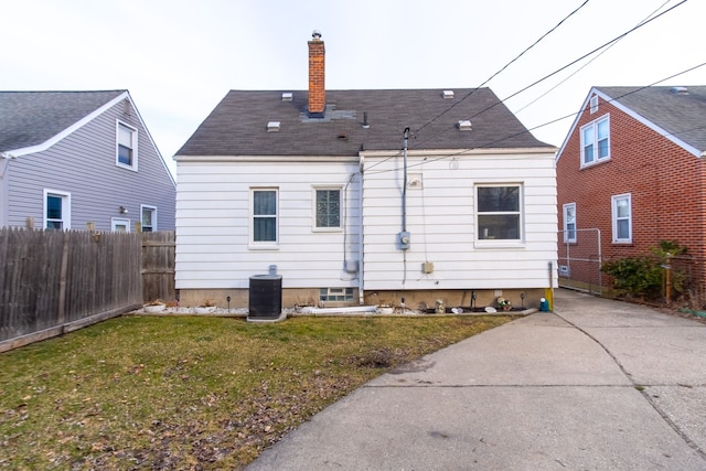 back of house featuring central AC and a lawn