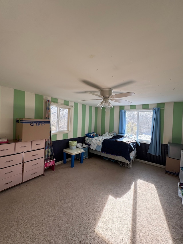 bedroom with multiple windows, ceiling fan, and carpet flooring