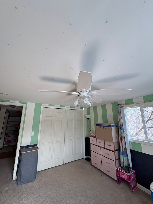 bedroom with ceiling fan, a closet, and light carpet