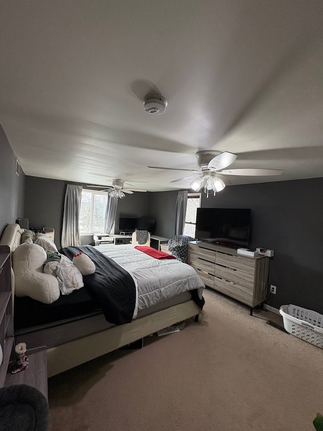 bedroom featuring multiple windows, ceiling fan, and carpet flooring