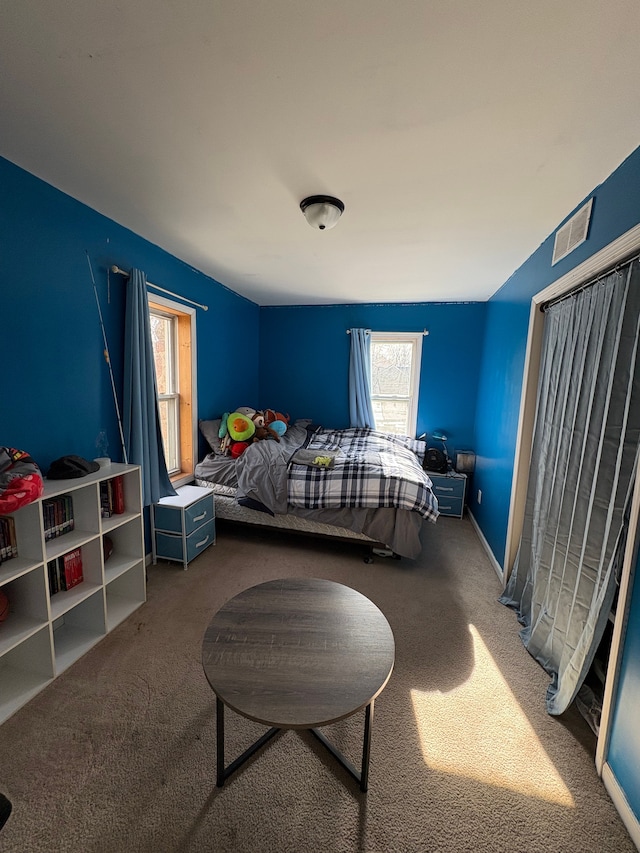 bedroom with multiple windows and carpet