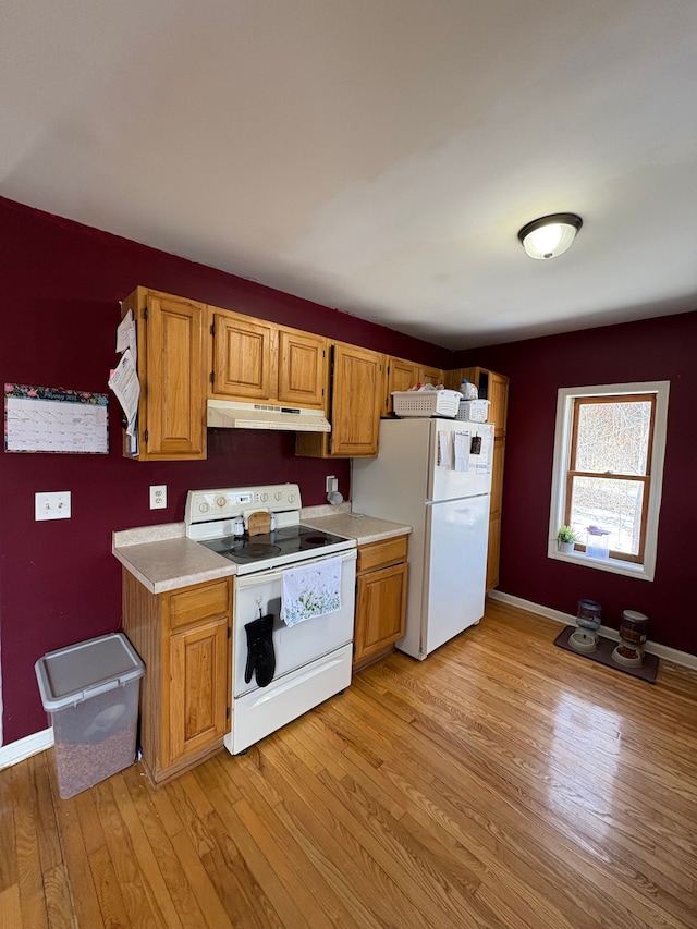 kitchen featuring white appliances and light hardwood / wood-style flooring