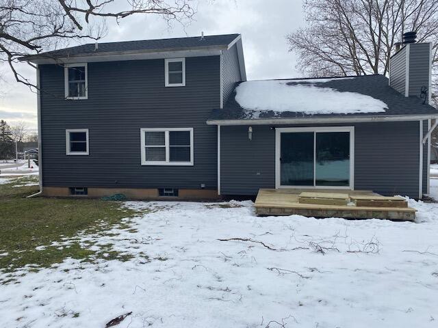 view of snow covered back of property