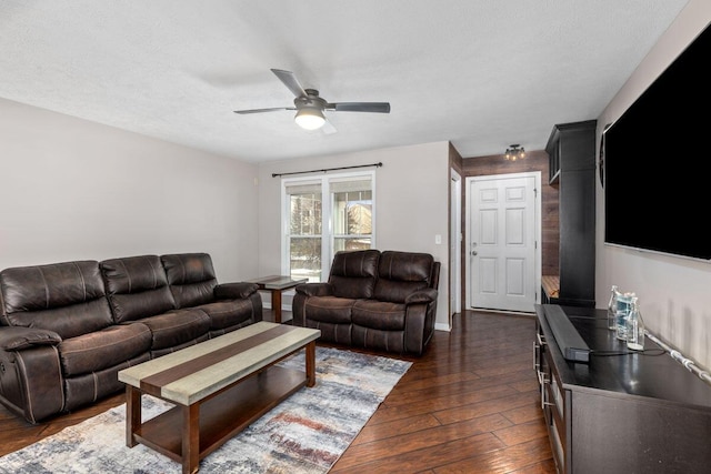 living room featuring ceiling fan, dark hardwood / wood-style floors, and a textured ceiling