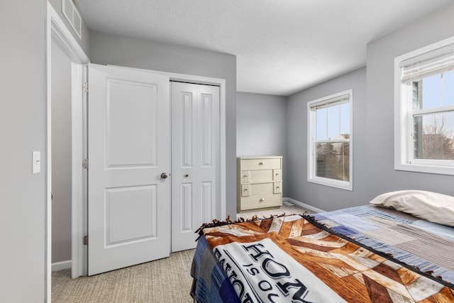 bedroom with a closet, multiple windows, and a textured ceiling