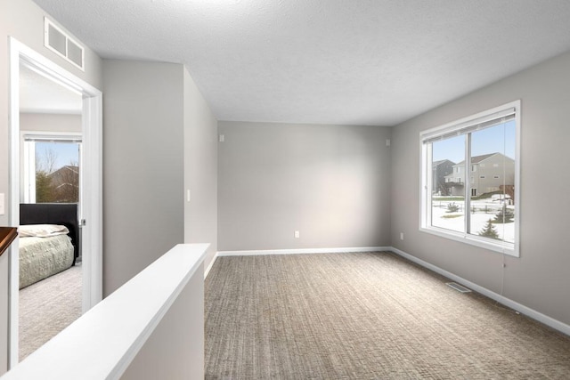 unfurnished room with carpet floors and a textured ceiling