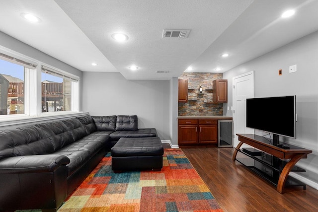 living room with dark hardwood / wood-style floors, beverage cooler, and a textured ceiling