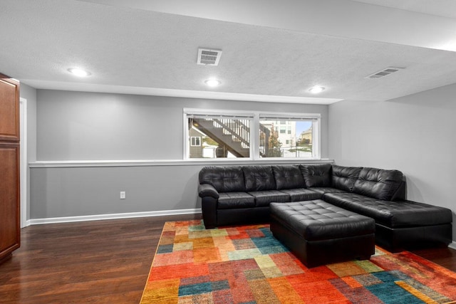 living room featuring dark wood-type flooring and a textured ceiling