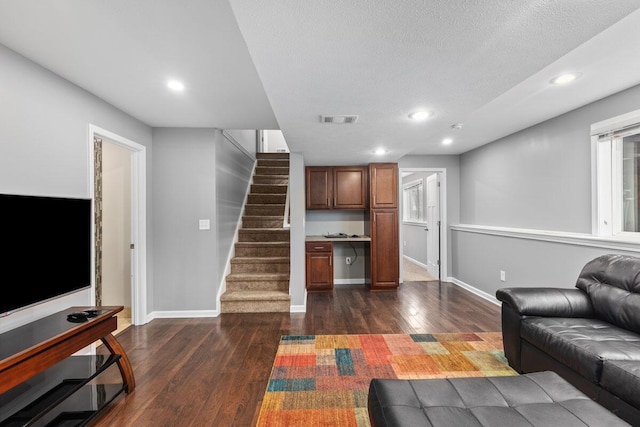 living room with dark wood-type flooring and a textured ceiling