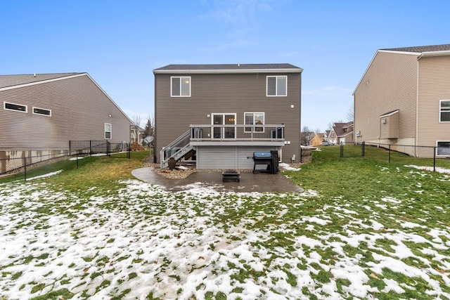 snow covered house with a yard and a deck