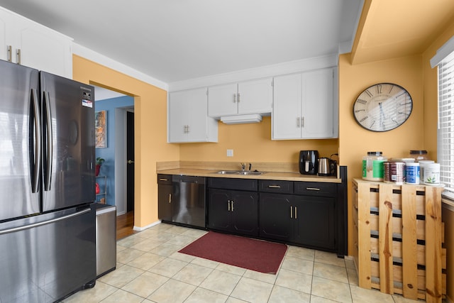 kitchen featuring white cabinetry, black dishwasher, sink, and stainless steel fridge