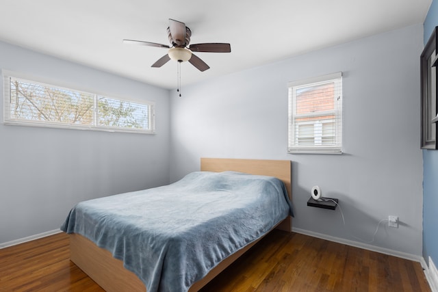 bedroom with dark hardwood / wood-style flooring and ceiling fan