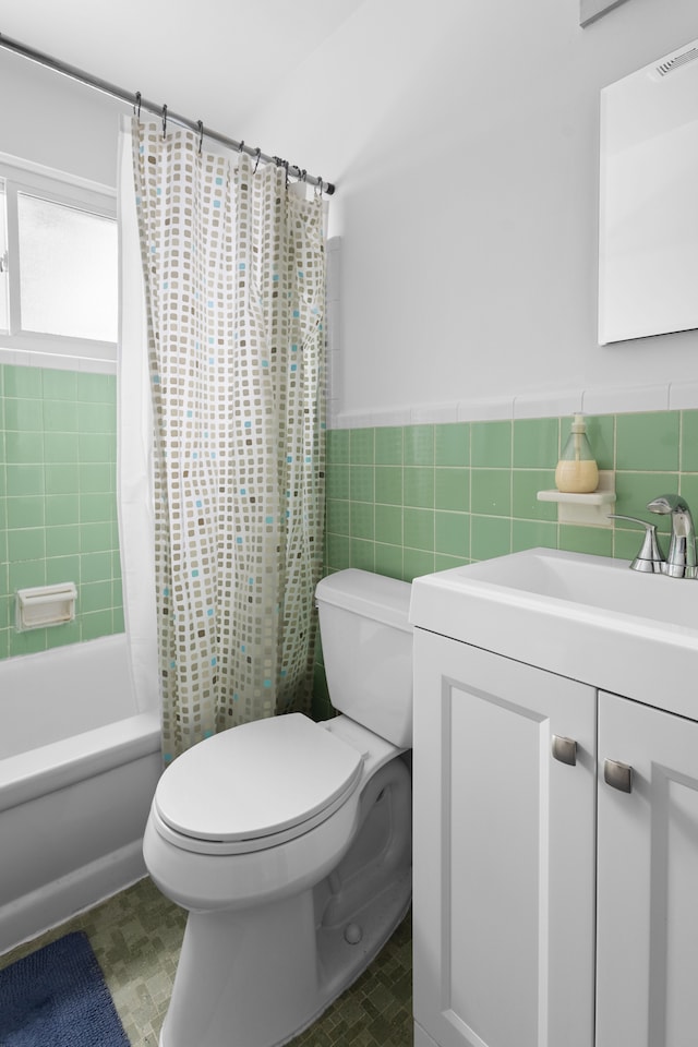 full bathroom with shower / bath combination with curtain, vanity, toilet, and tile walls