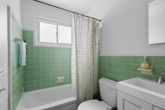 full bathroom with tile walls, vanity, toilet, and shower / bath combo