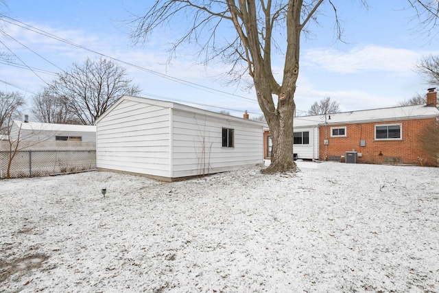 snow covered property with central AC unit