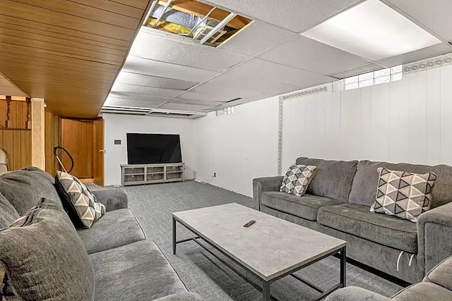 carpeted living room featuring wood walls