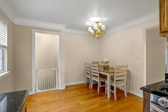 dining space with a notable chandelier, crown molding, and light hardwood / wood-style flooring