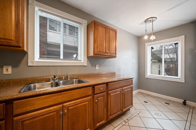 kitchen with sink, light tile patterned floors, and decorative light fixtures