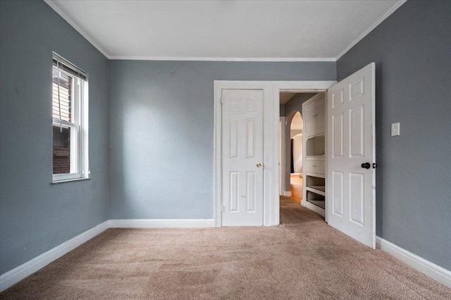 unfurnished bedroom with crown molding and carpet floors