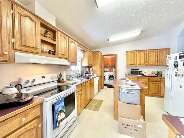 kitchen featuring white appliances, lofted ceiling, washer and dryer, and a textured ceiling