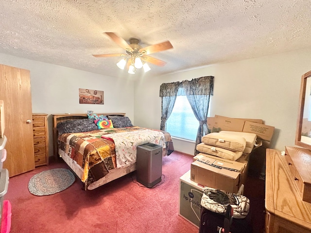 bedroom with ceiling fan, carpet, and a textured ceiling