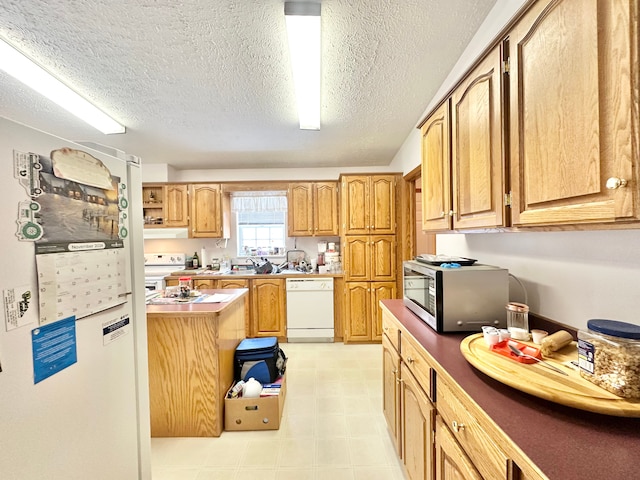 kitchen featuring white appliances and a textured ceiling