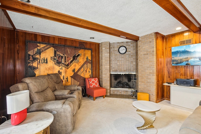 carpeted living room with a brick fireplace, a textured ceiling, beamed ceiling, and wood walls