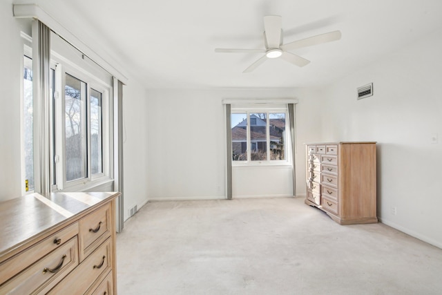 carpeted bedroom with ceiling fan and multiple windows