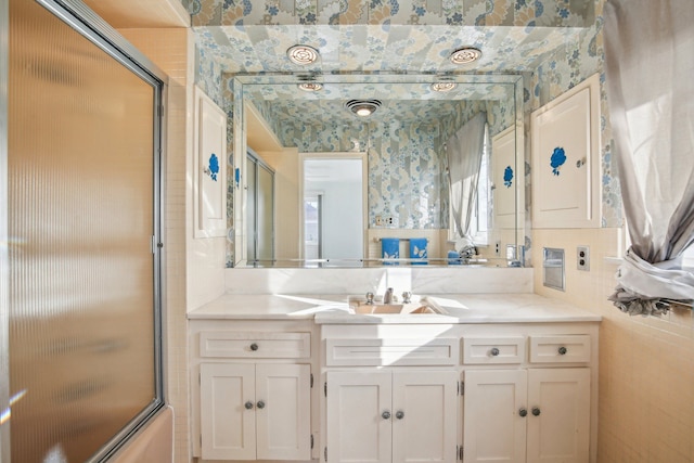 bathroom with vanity and shower / bath combination with glass door