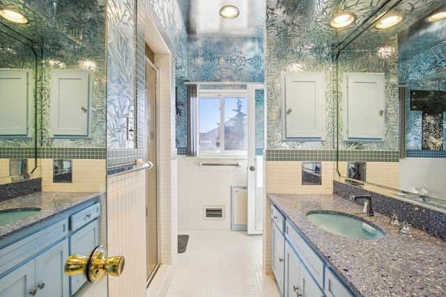 bathroom with tile patterned flooring, vanity, and tile walls