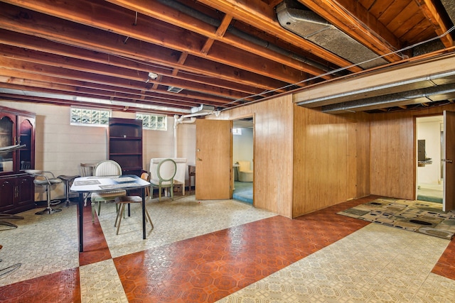 basement featuring wooden walls