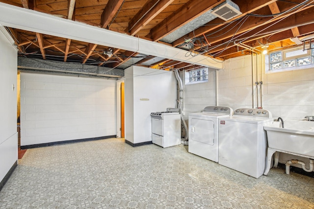 clothes washing area featuring a healthy amount of sunlight, washer and clothes dryer, and sink