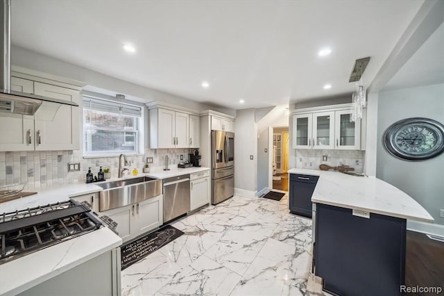 kitchen with stainless steel appliances, light stone countertops, sink, and white cabinets