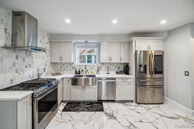 kitchen featuring white cabinets, appliances with stainless steel finishes, sink, and wall chimney range hood