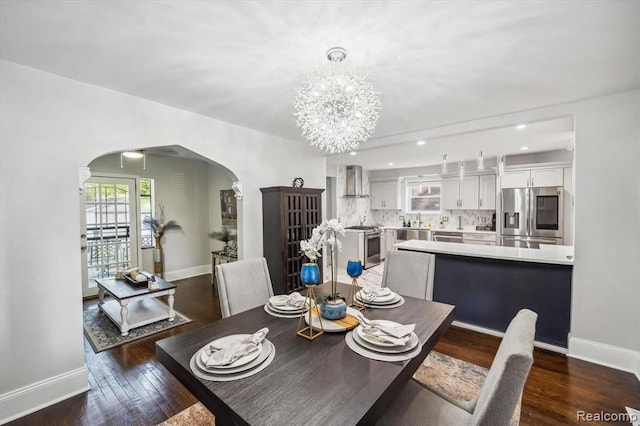 dining space featuring a notable chandelier, sink, and dark hardwood / wood-style floors