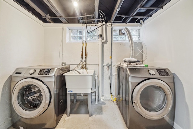 clothes washing area with separate washer and dryer and sink