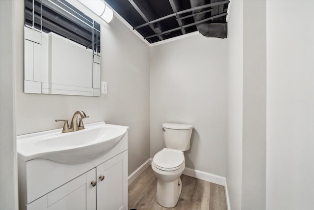 bathroom with hardwood / wood-style flooring, vanity, and toilet