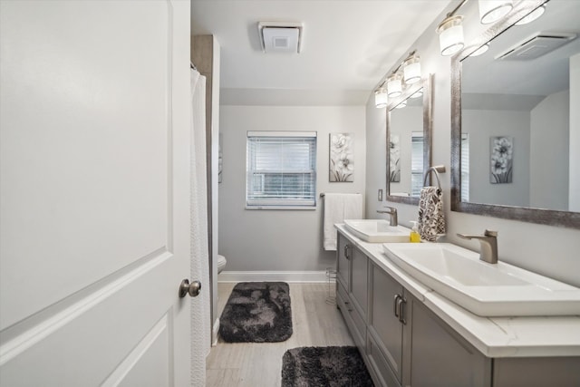 bathroom featuring vanity, hardwood / wood-style floors, plenty of natural light, and toilet