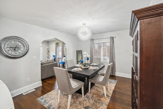 dining space with an inviting chandelier and dark hardwood / wood-style flooring