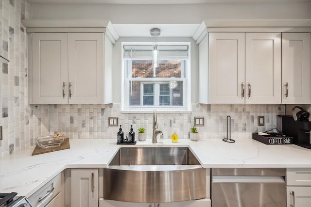 kitchen with sink, light stone counters, white cabinetry, tasteful backsplash, and dishwasher